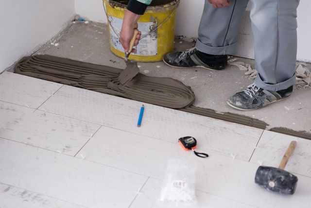 Worker Installing The Ceramic Wood Effect Tiles On The Floor